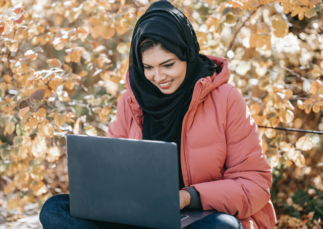 Woman outdoors on her laptop working.