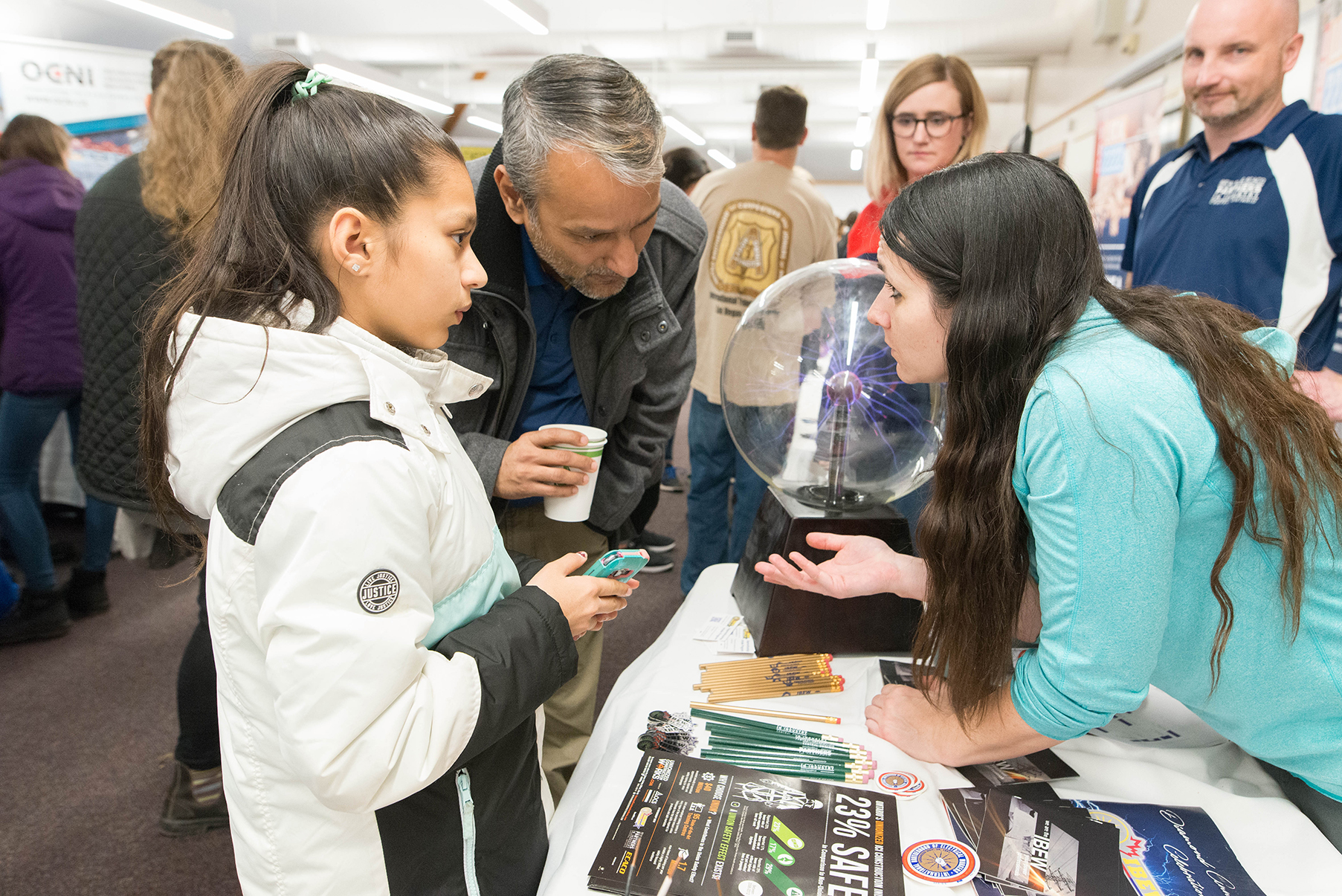 A father and daughter discuss careers with a female electrician at Build a Dream's career discovery expo.